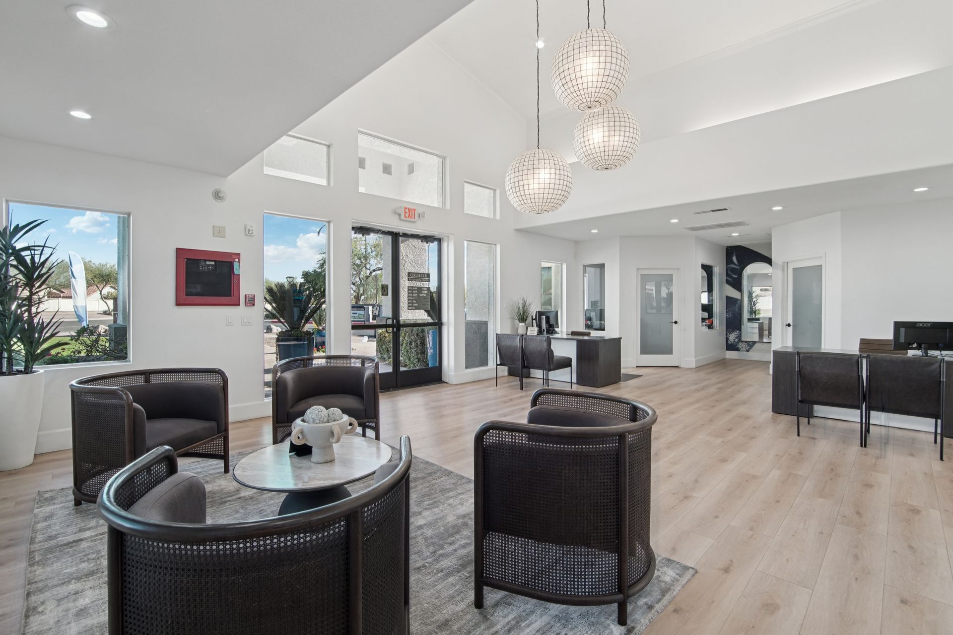 Modern lobby with seating, windows, and light wood flooring.