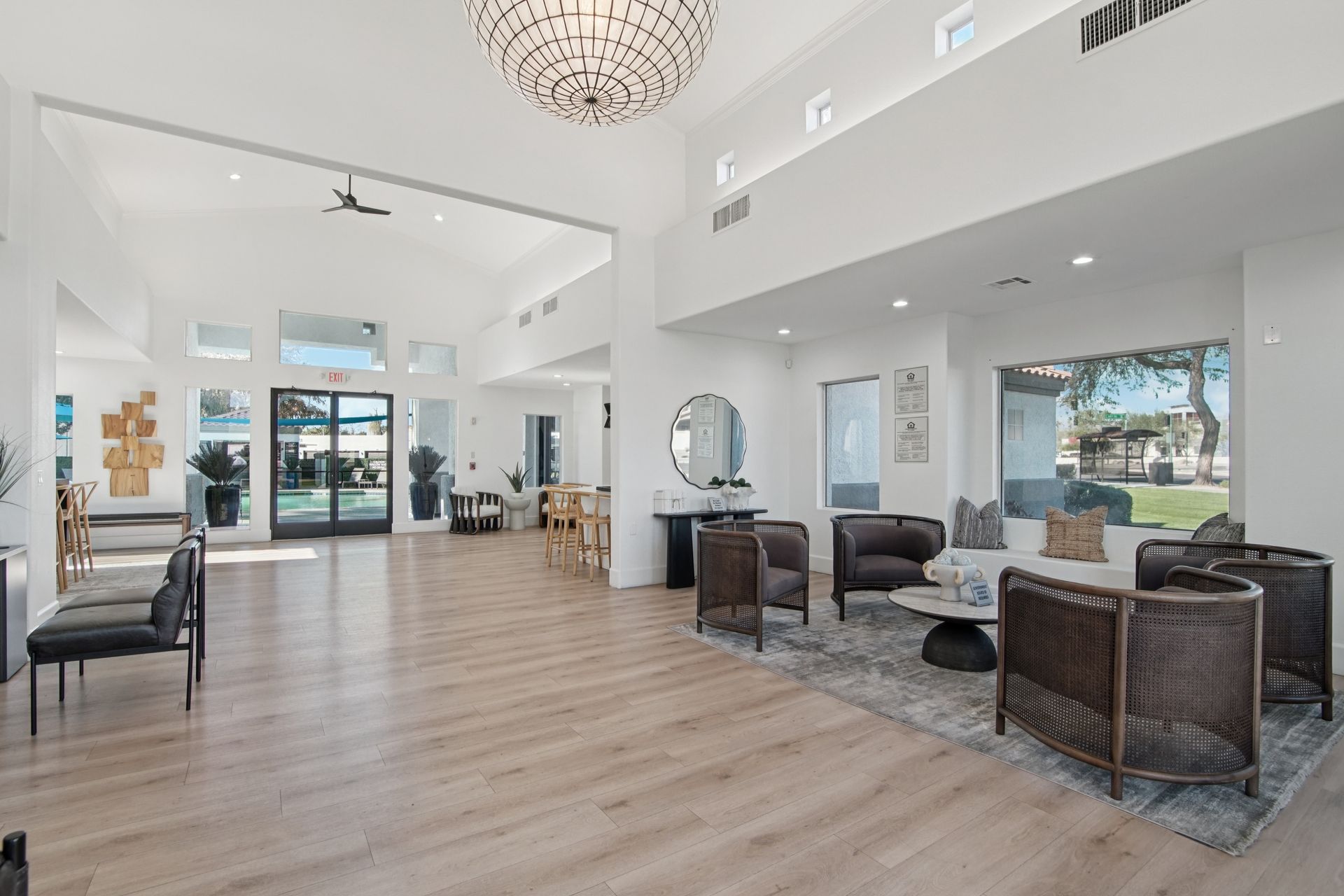 Spacious, bright lobby with modern furniture, hardwood floors, and a large chandelier.