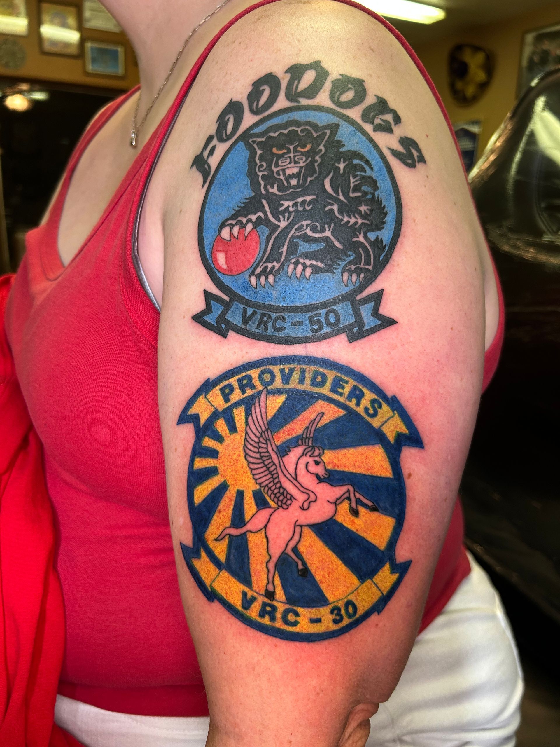 Tattoos on a person's upper arm. Top tattoo: 