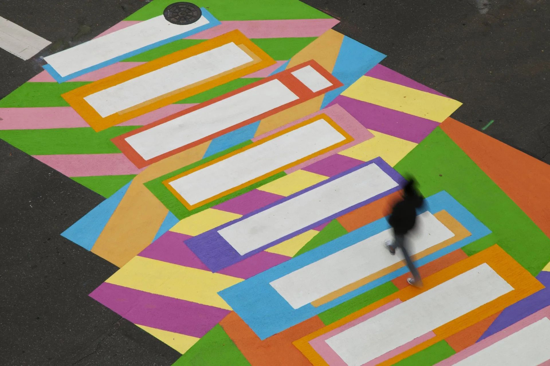 A person is crossing a colorful painted crosswalk