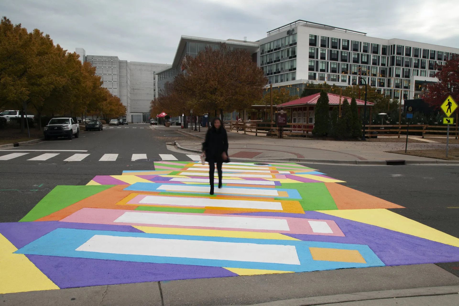 A person is walking across a colorful crosswalk.
