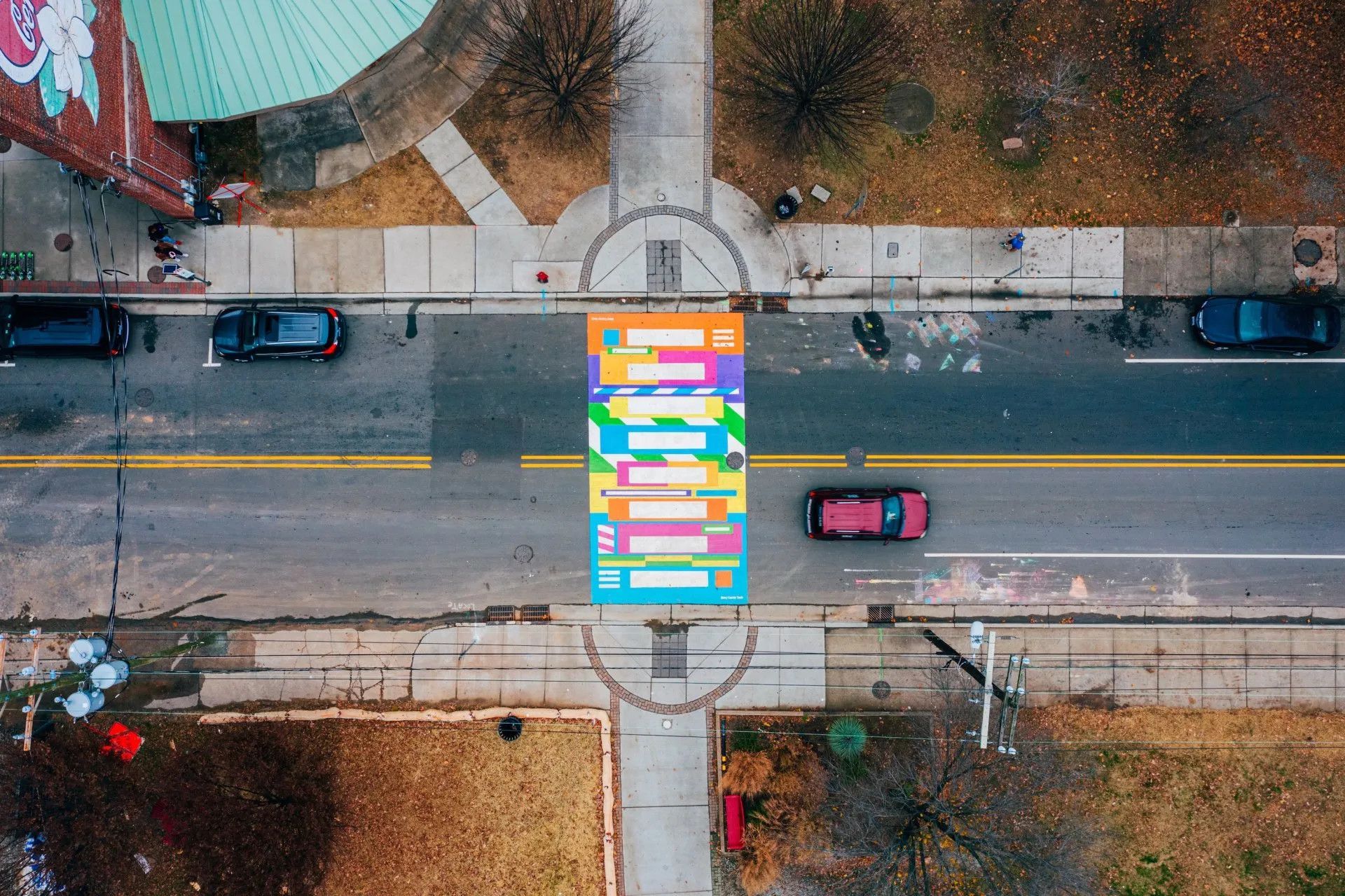An aerial view of a colorful crosswalk on the side of a street.