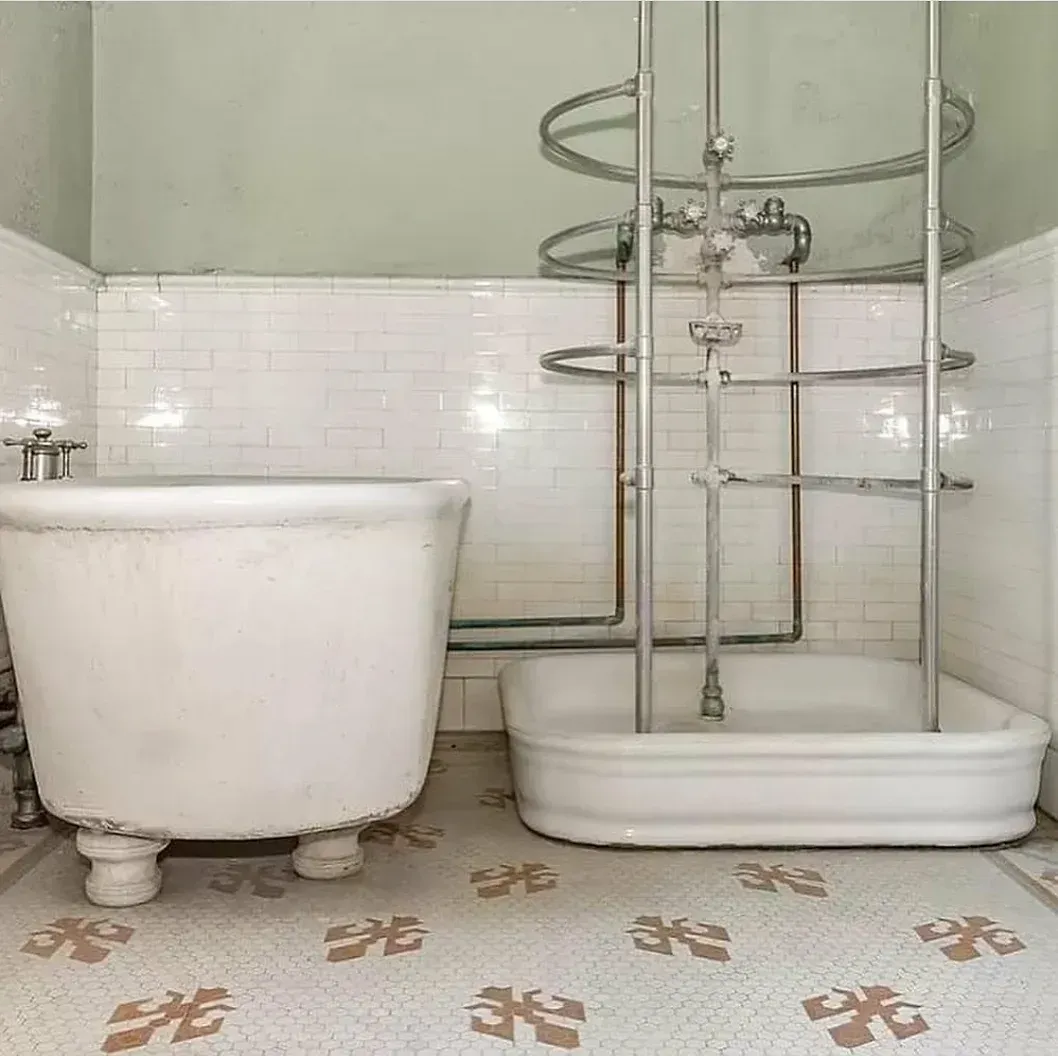 A bathroom with two bathtubs and a shower.