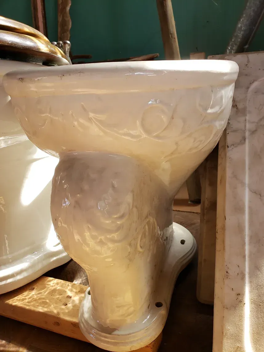 A white toilet is sitting on a wooden table