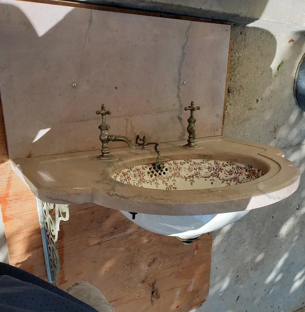 A sink with a faucet that has the letter r on it