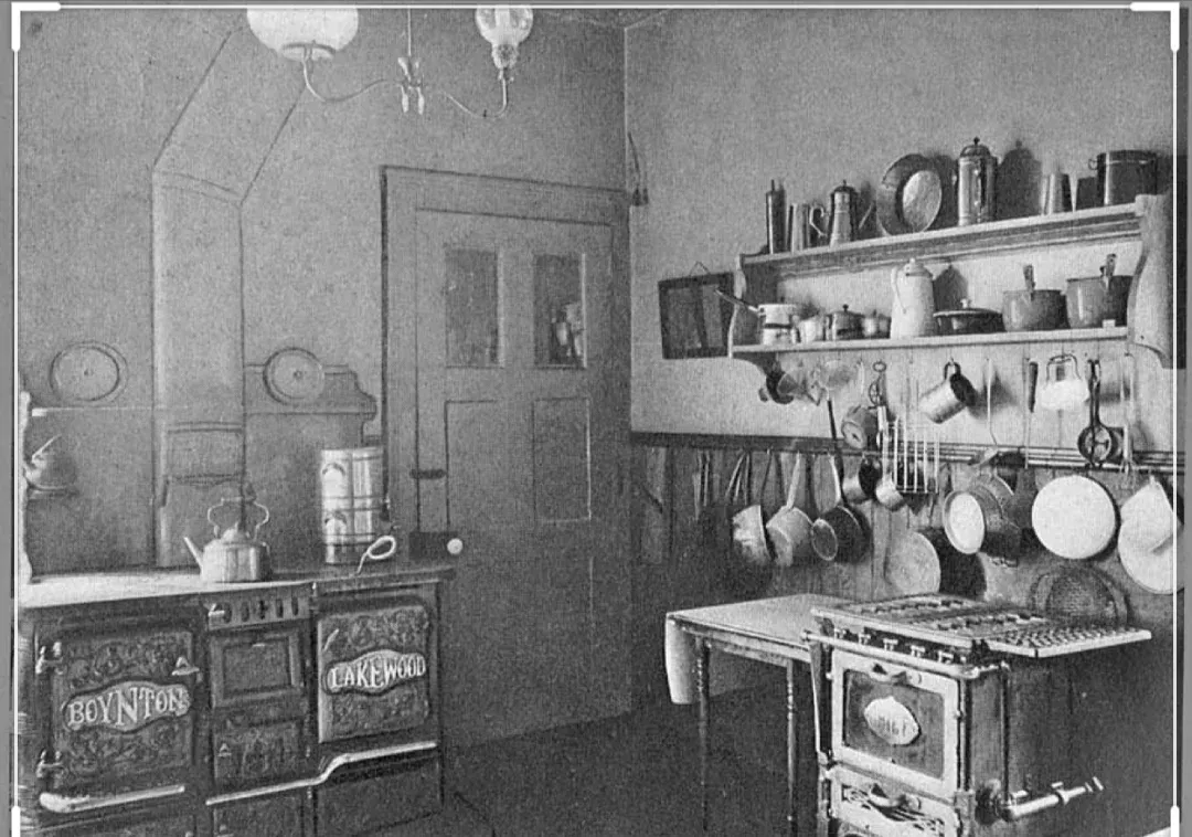 A black and white photo of a kitchen with a stove and a sink