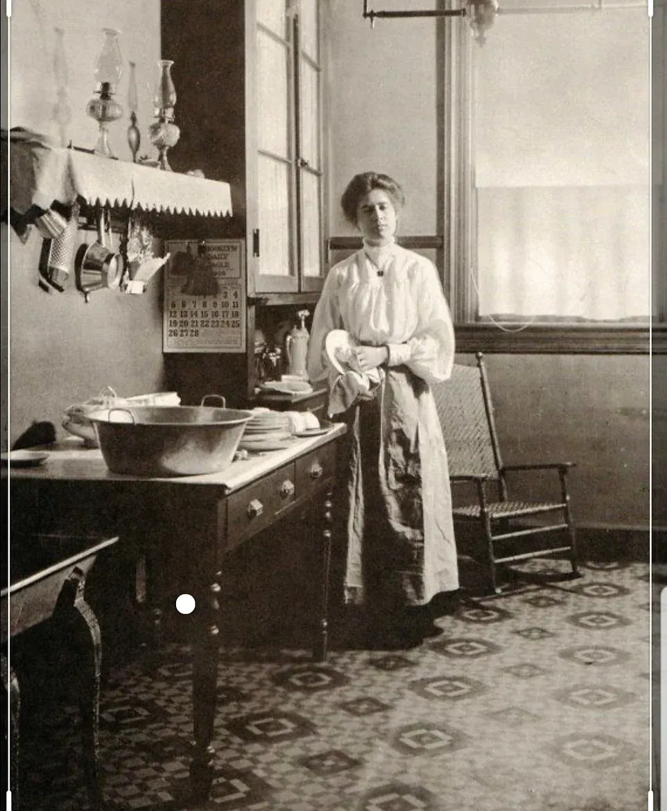 A black and white photo of a woman in a kitchen