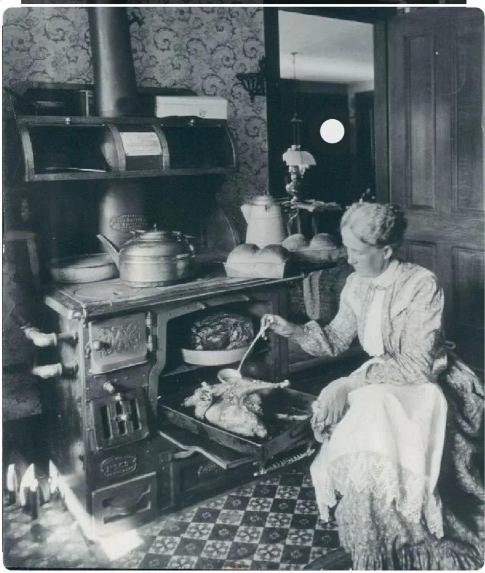 A black and white photo of a woman in a kitchen