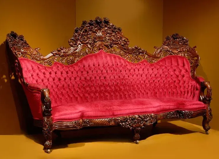 A red couch is sitting in a corner of a room