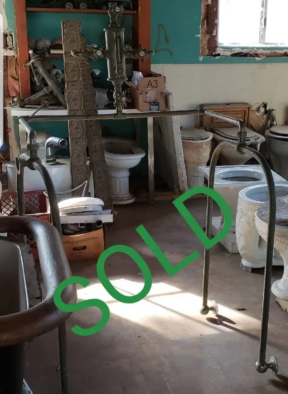 A room with toilets and a sign that says sold