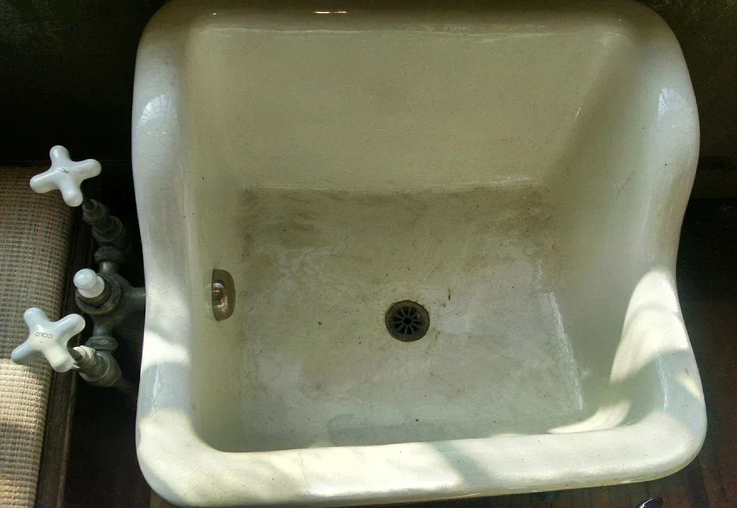 A white sink with a faucet on the side of it.