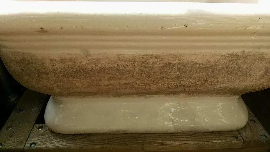 A white bowl is sitting on top of a wooden table.