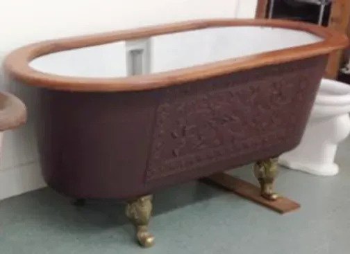 A bathtub is sitting on the floor next to a toilet.