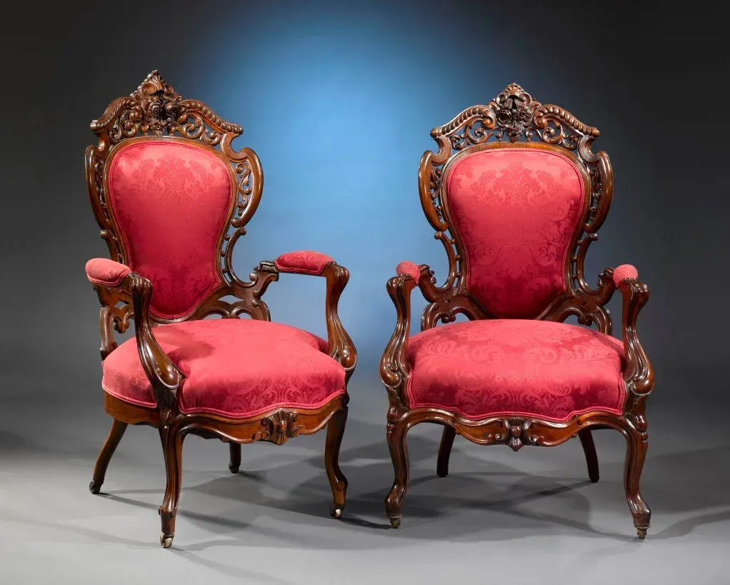 Two red chairs are sitting next to each other on a gray surface