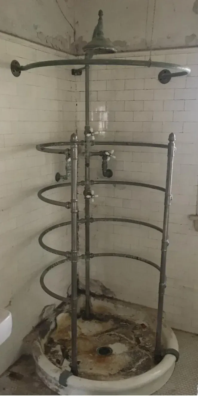 A bathroom with a spiral shower head and a sink