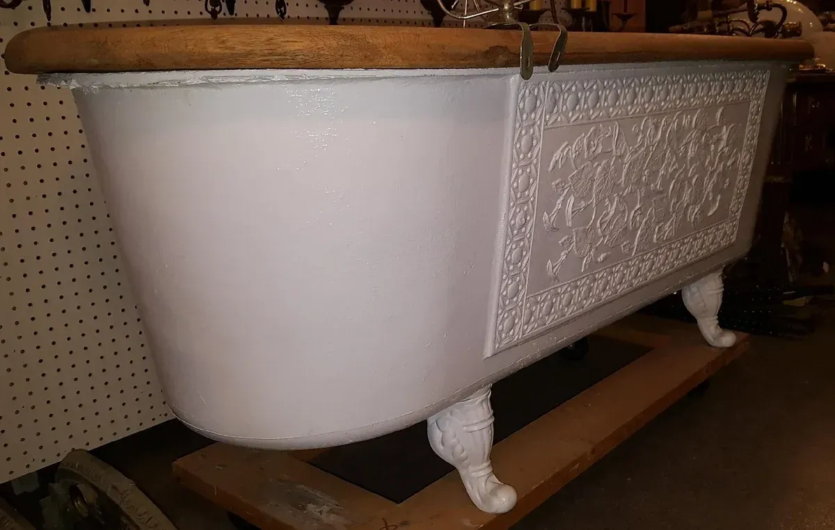 A white bathtub is sitting on top of a wooden table.
