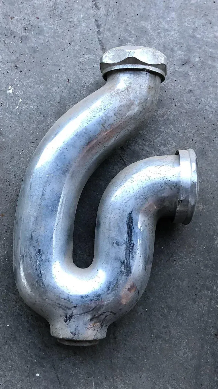 A metal pipe is sitting on a concrete surface.