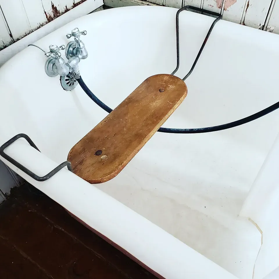 A bathtub with a wooden seat attached to it