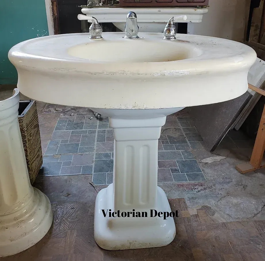 A white pedestal sink with the words victorian depot on the bottom