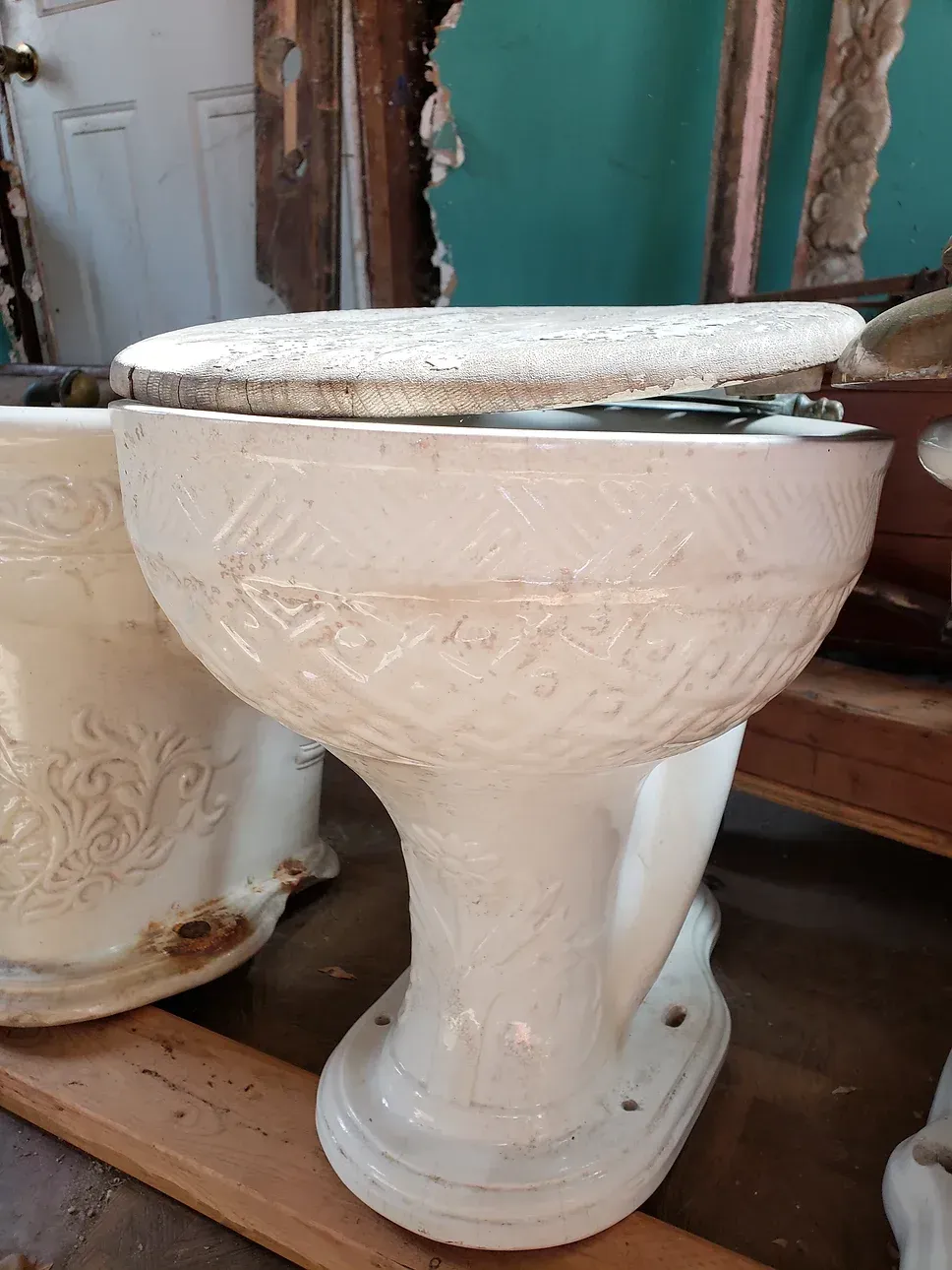 A white toilet is sitting on top of a wooden shelf.