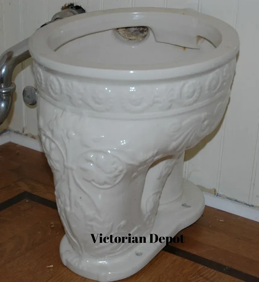 A victorian depot toilet sits on a wooden floor