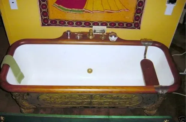 A bathtub in a bathroom with a picture on the wall above it