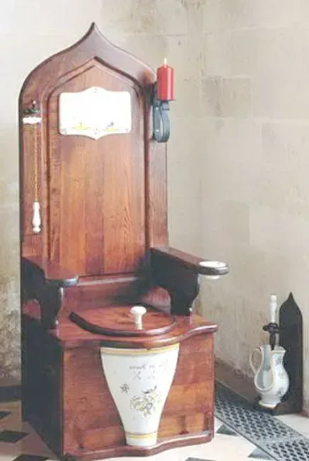 A wooden toilet with a candle on top of it