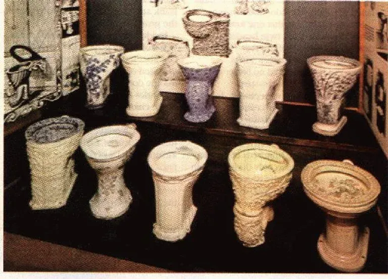 A bunch of toilets are lined up on a table