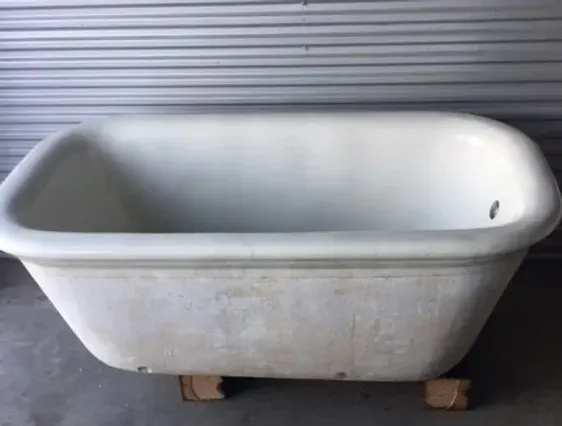 A white bathtub is sitting on a wooden pallet
