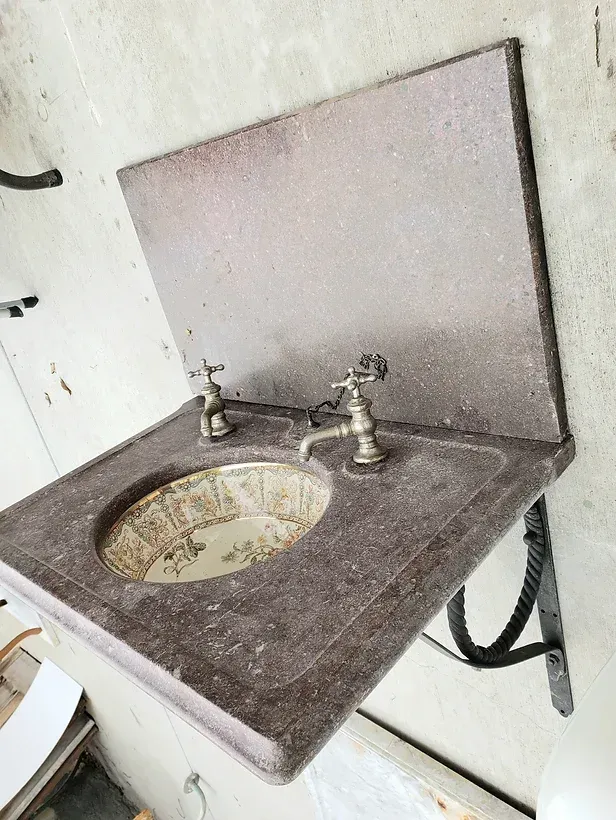 A bathroom sink with two faucets on it
