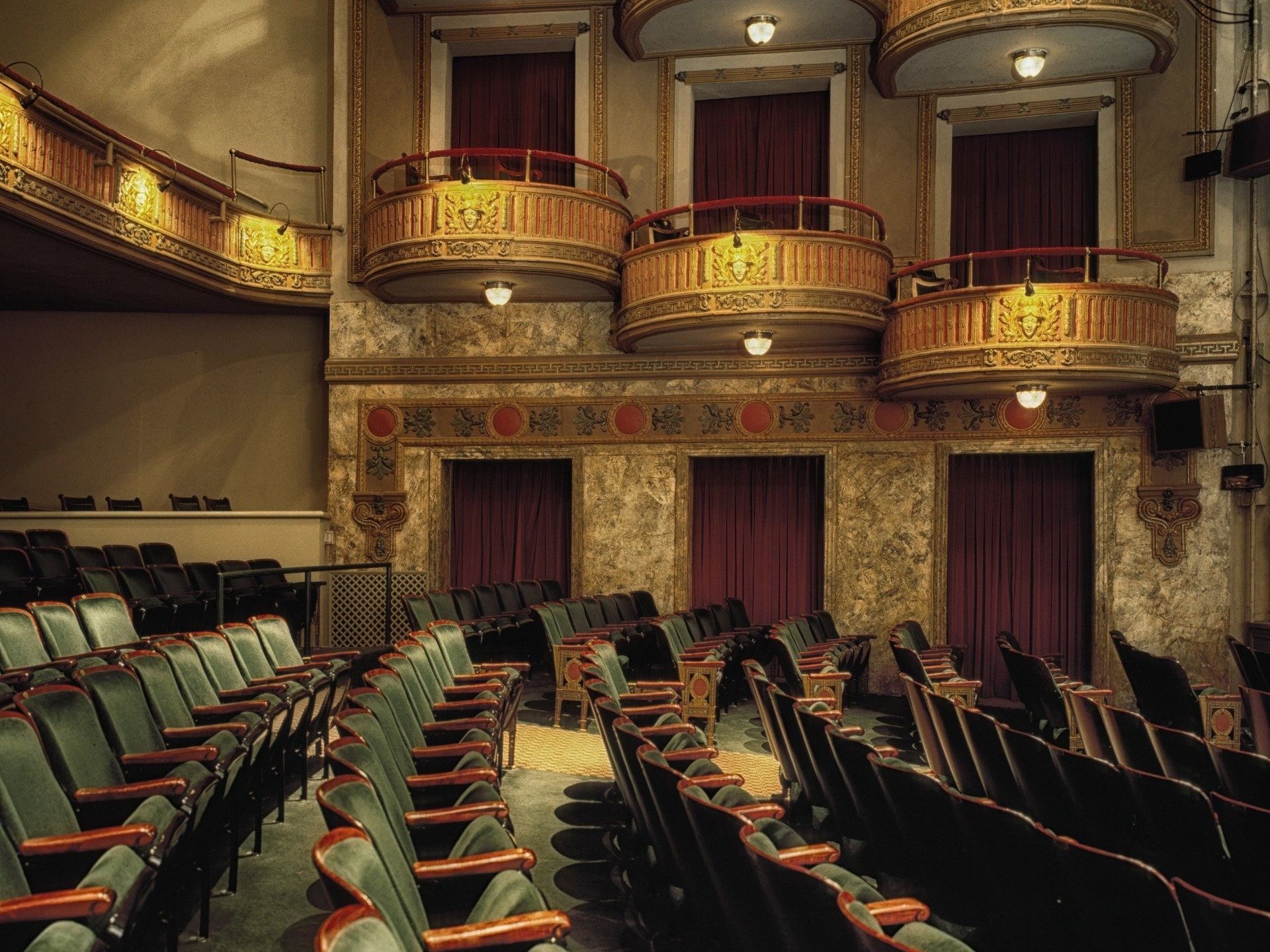 An empty auditorium with rows of seats and balconies