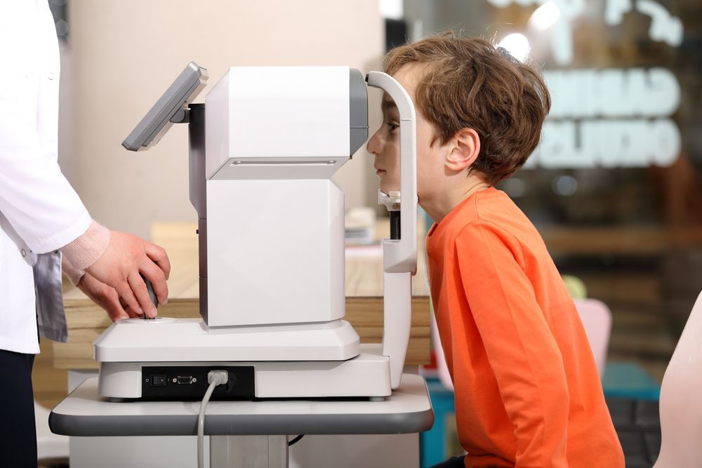 A young boy is getting his eyes checked by an optometrist
