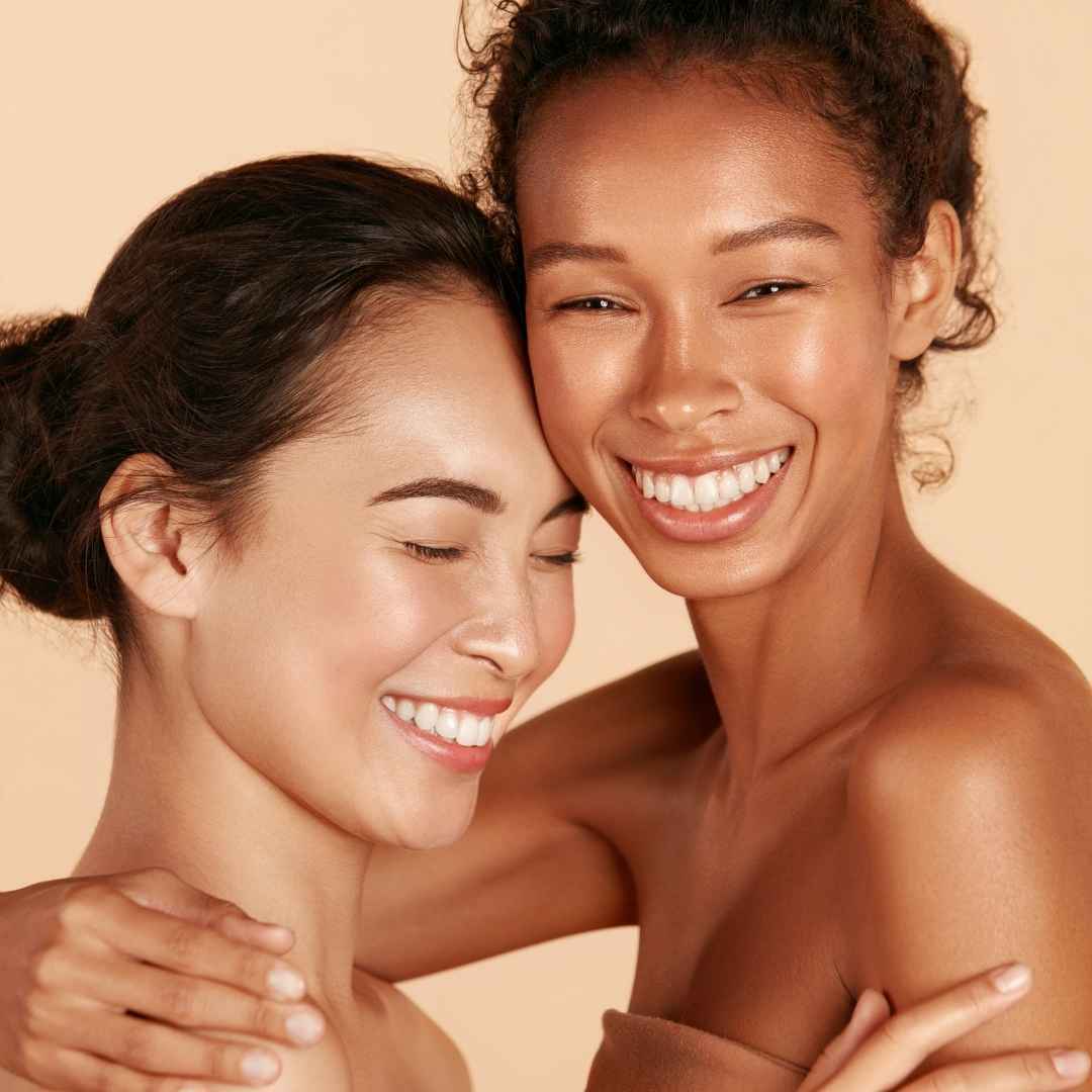 Two women are hugging each other and smiling for the camera.