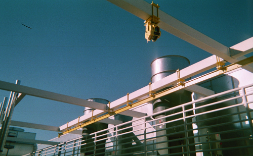 A crane is hanging from the roof of a building