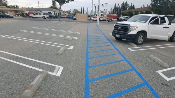 A white truck is parked in a parking lot with blue lines.
