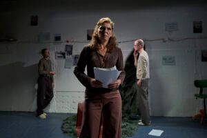 Frau aus Schsupielergruppe auf der Bühne mit Script in der Hand