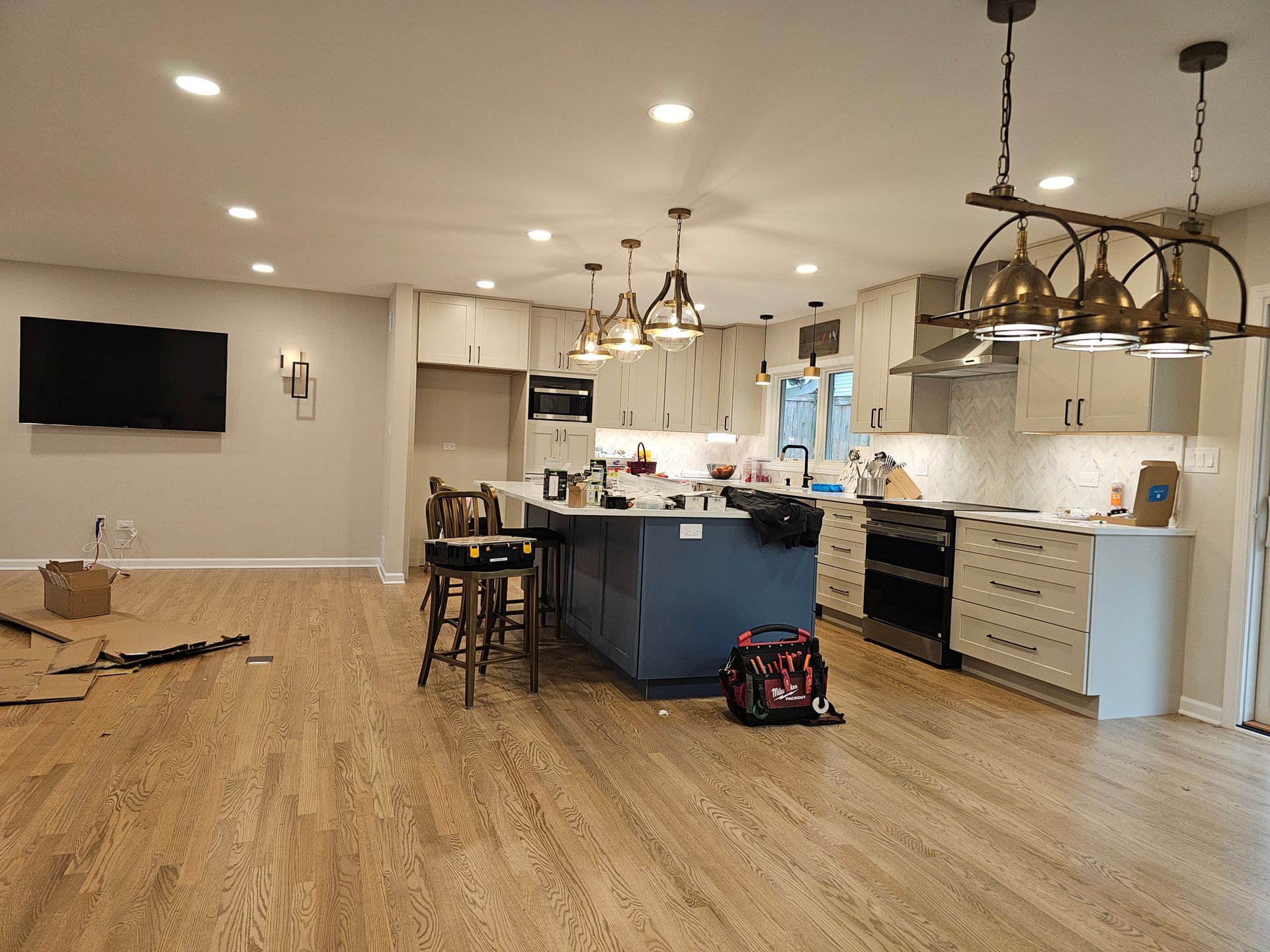 A kitchen with a large island and a flat screen tv.