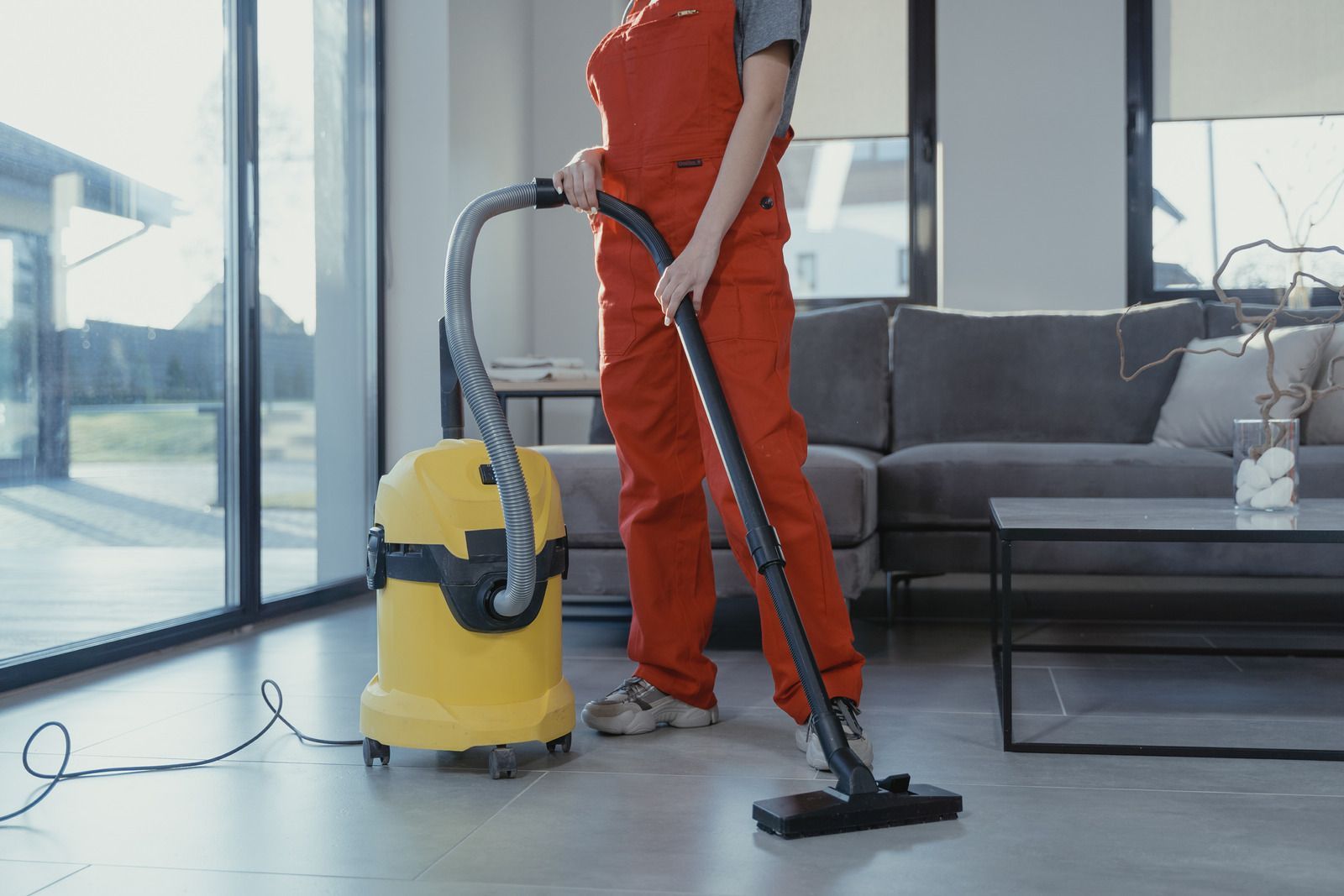 A woman is using a vacuum cleaner in a living room.