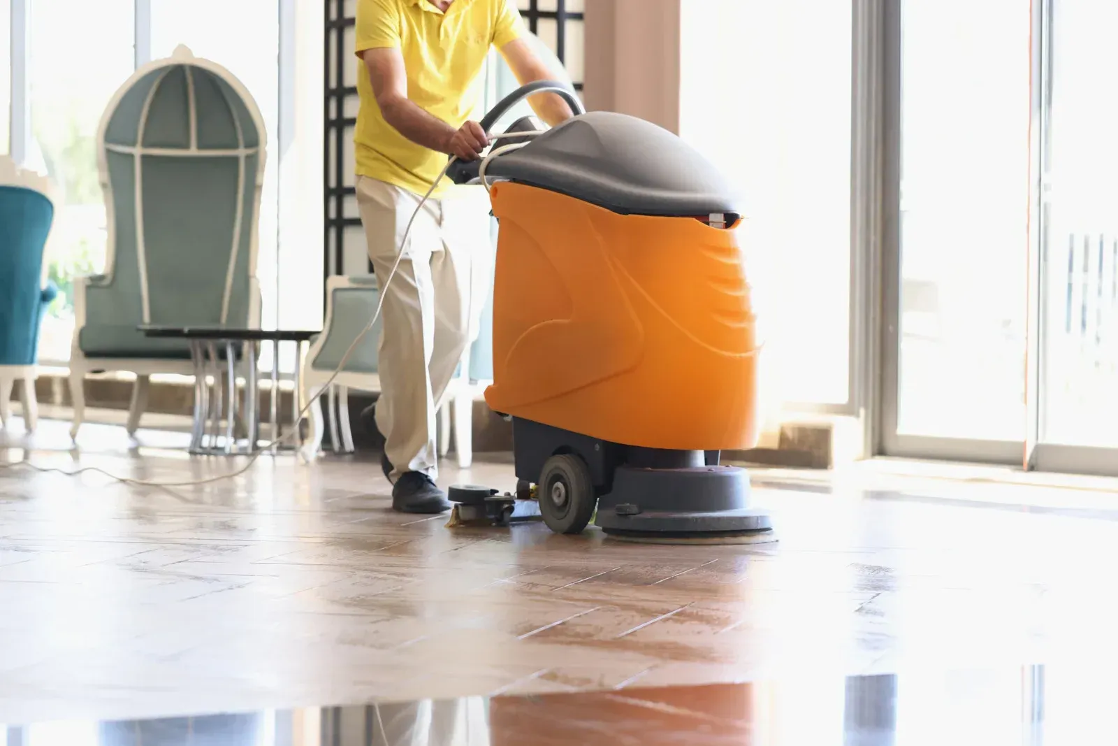 A man is cleaning the floor with a machine.