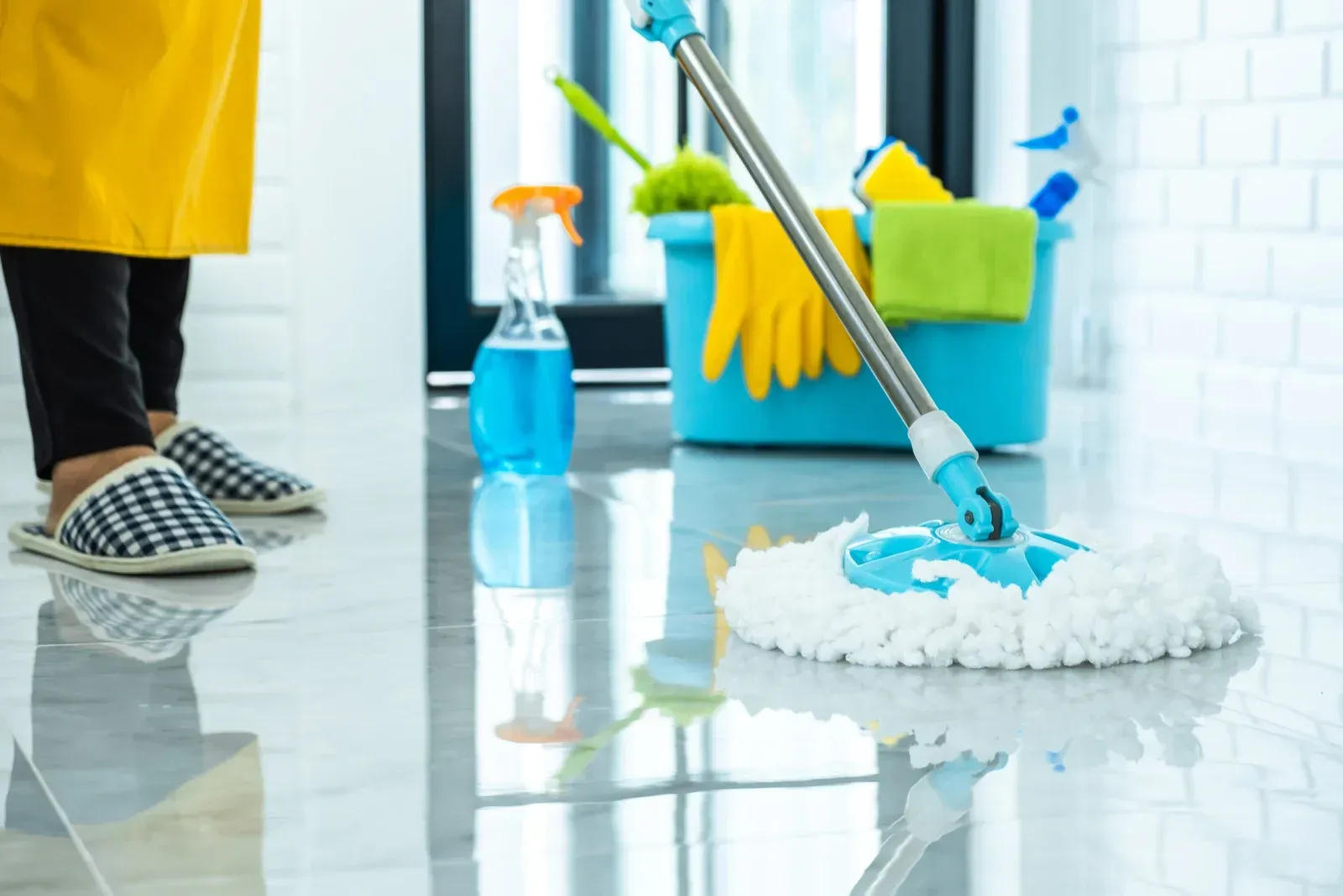 A woman is cleaning the floor with a mop.
