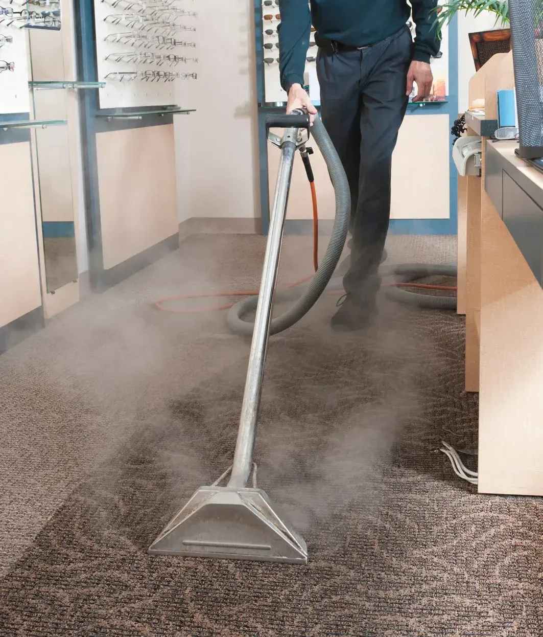 A man is using a vacuum cleaner to clean a carpet