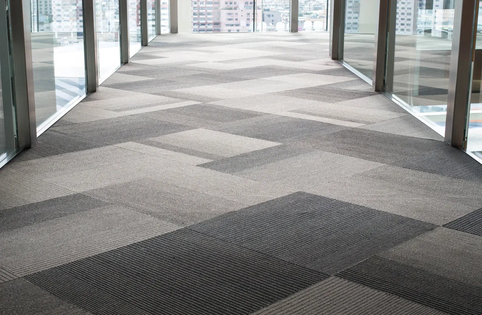 A long hallway with a carpeted floor and a lot of windows.