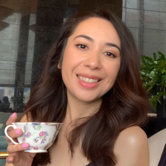 A woman with pink nails is holding a cup of tea