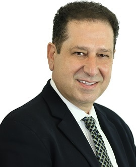 A man in a suit and tie is smiling for the camera.