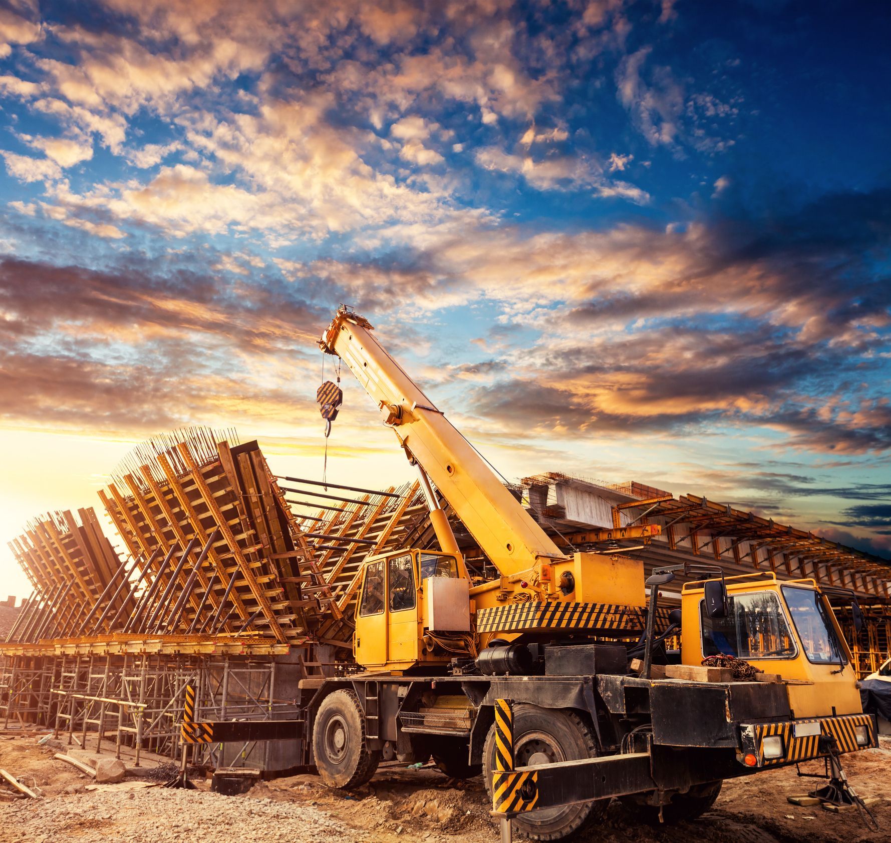 Construction crane lifting equipment against a clear blue sky for hire services. Construction crane lifting equipment against a clear blue sky for hire services.