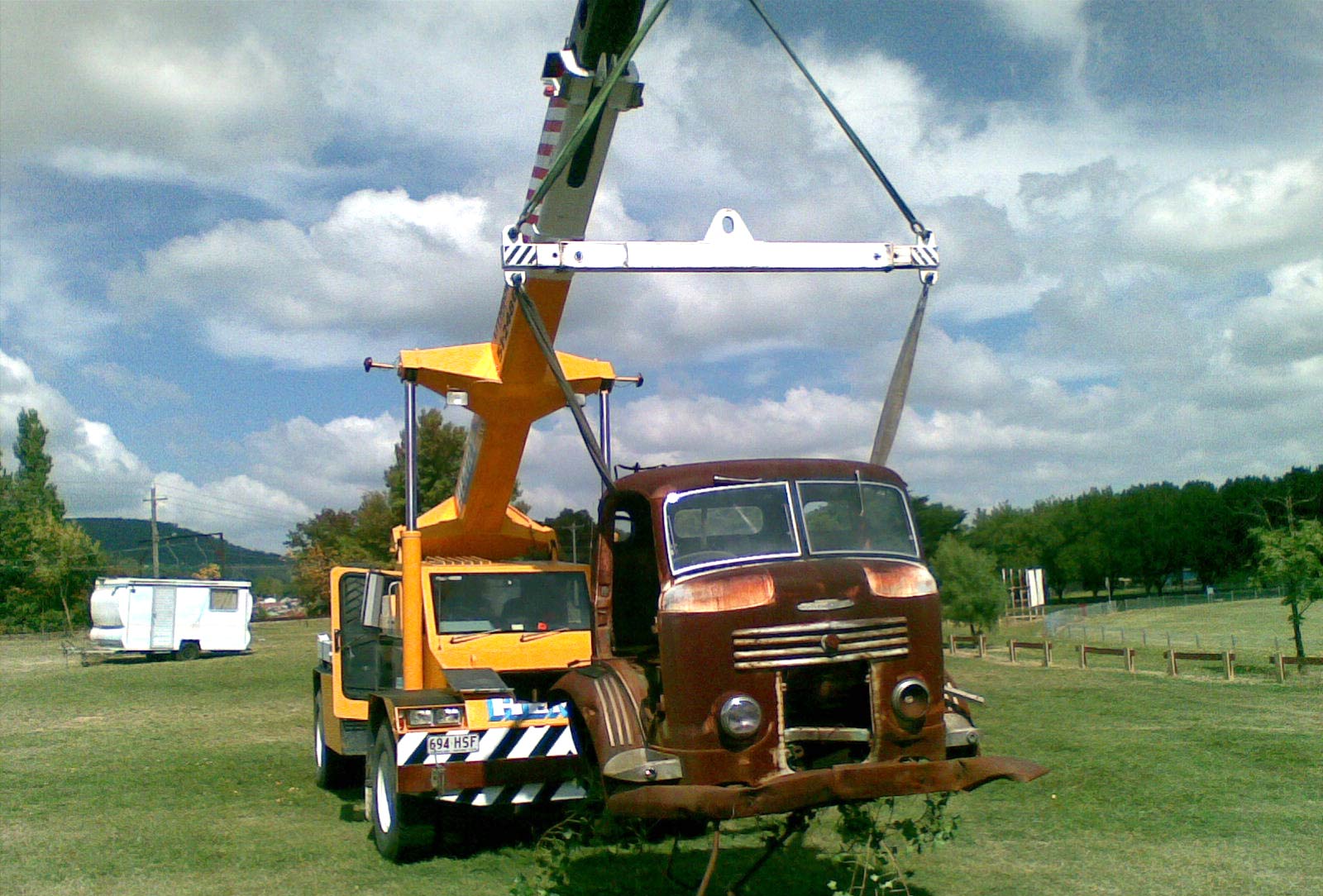 Construction crane lifting equipment against a clear blue sky for hire services.
