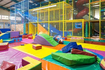 Indoor children's playground with colorful soft play equipment, slides, and climbing structures.