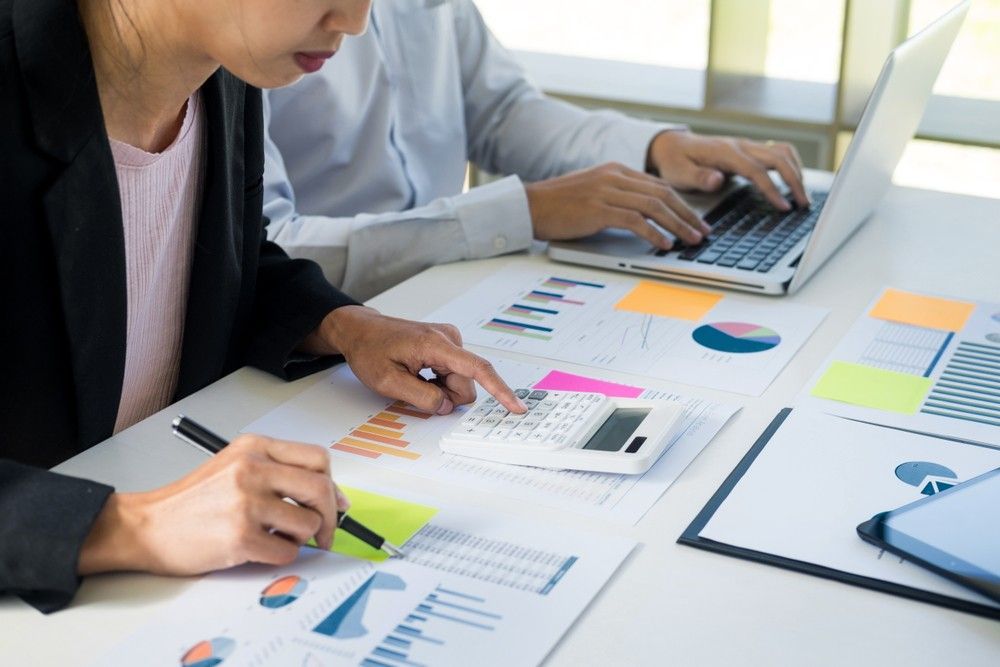 Two People Are Sitting at a Table With a Laptop and a Calculator — Eacham Accounting and Audits in Tablelands, QLD
