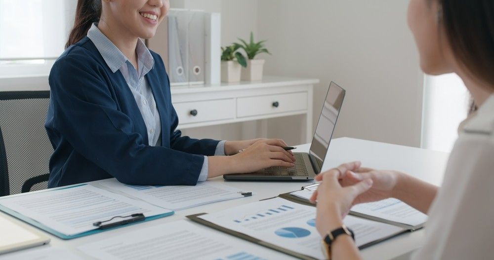 A Woman is Sitting at a Table With a Laptop — Eacham Accounting and Audits in Malanda, QLD