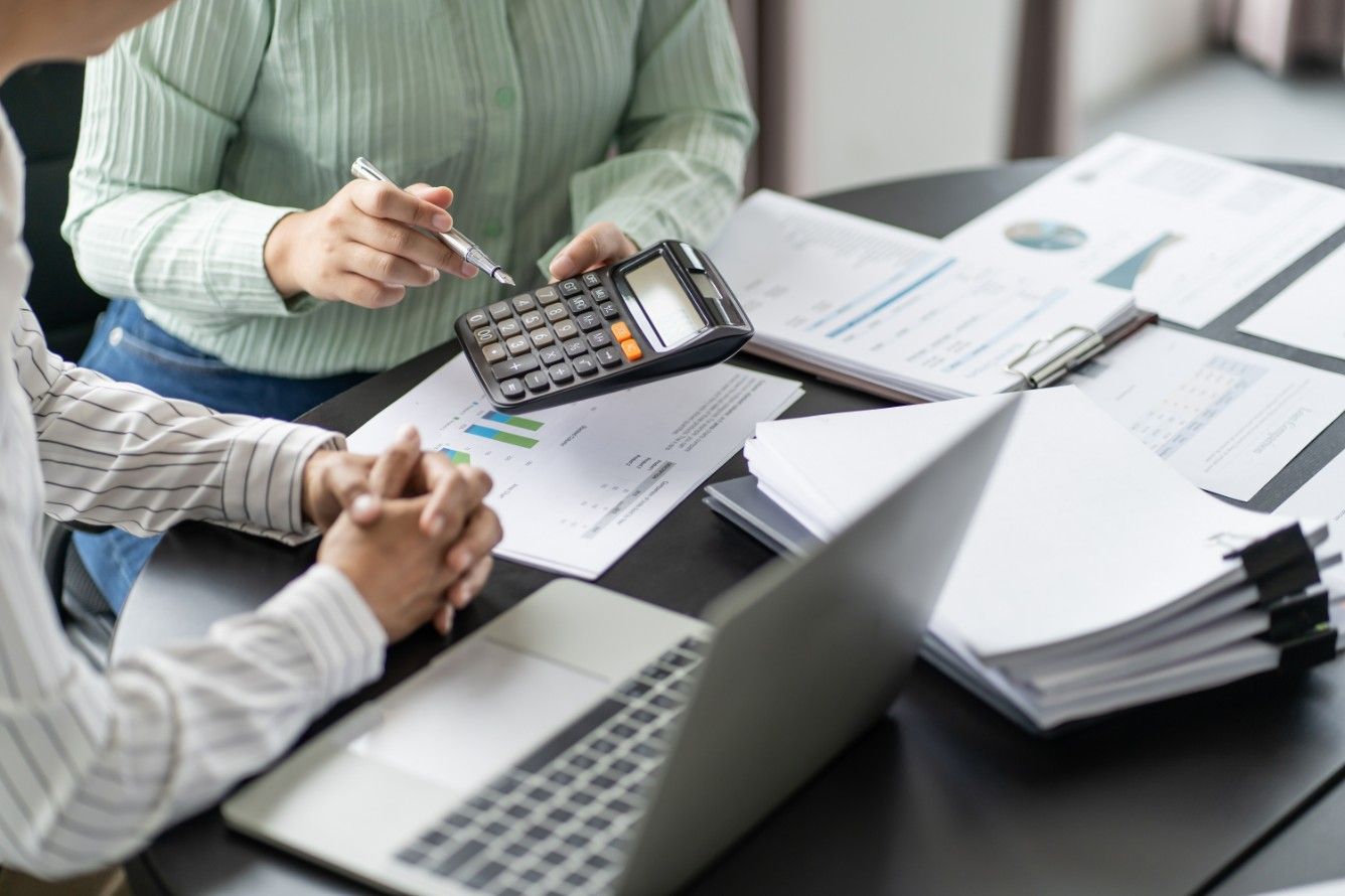 A Man and a Woman Are Sitting at a Table With a Laptop — Eacham Accounting and Audits in Cassowary Coast, QLD